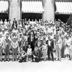 Crowd of white people standing on hotel stairs