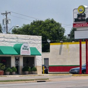 Building with green awnings and road sign "Pho Hoang Vietnamese Noodle Soup"