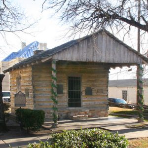 small wooden A-frame building with iron barred door