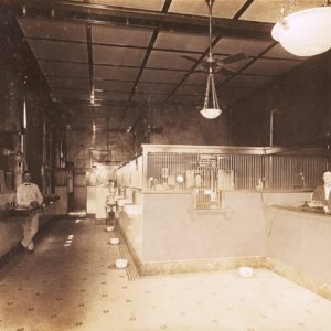 Bank interior with teller, telephone service operator, and other employee.