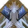 upward view of the corner of a multistory white brick building symmetrically mounted banners saying "the rep share the experience"