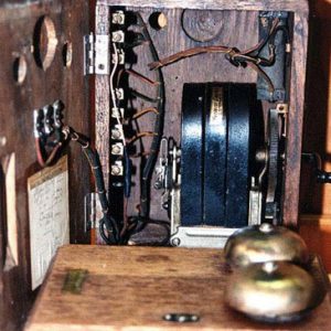 an opened crank telephone showing the inner mechanisms