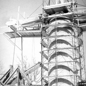 Unfinished statue of Jesus covered in scaffolding with trailer in foreground