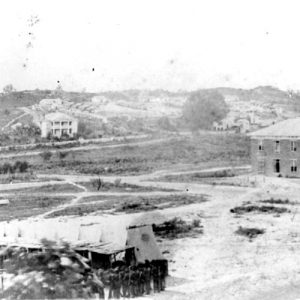 Men in military uniforms with mansion and various other buildings in the background