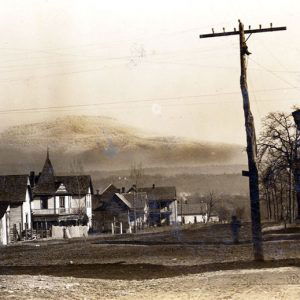 Street with wooden buildings and mountain in the background