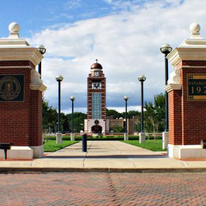 two brick posts with clock tower in background