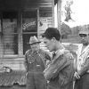 some men in working clothing outside wooden building "General Store"