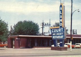 Single story red brick building with large sign advertising cafe and motel