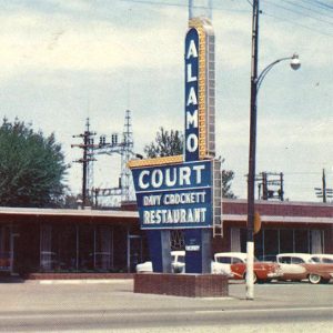 Single story red brick building with large sign advertising cafe and motel