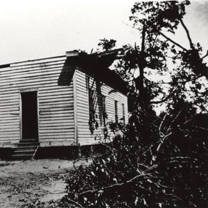 Wooden church building with two front doors missing roof