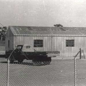 Truck in front of metal building with single bay and windows