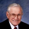 Older white man in suit and tie with glasses