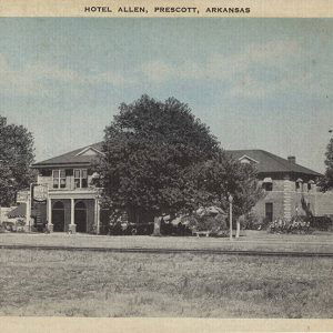 Long multistory building with large trees in front.