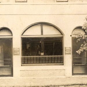 One story white building with two front doors on either side of central window