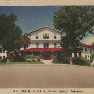 Multistory white building with covered entrance and trees