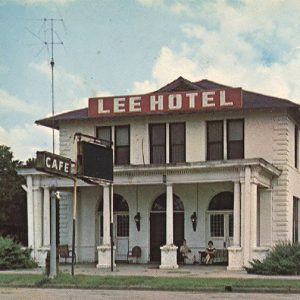 Two story white building "Lee Hotel" and "Cafe"