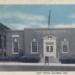 Single story brick building with front facing windows and American flag on roof