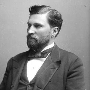 White man in suit with beard and mustache