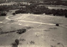 Aerial view of white tents set up in rows on oval racetrack