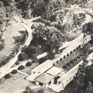 Aerial view of structures and wooded area