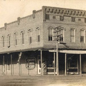 Two story brick storefront building with covered walkway