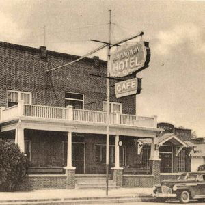 Two story brick building with upper porch and railing "Broadway Hotel and Cafe"