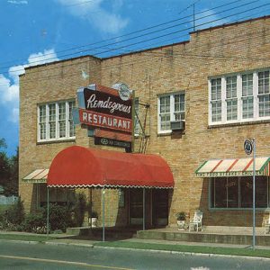 Two story tan brick building with Rendezvous Restaurant sign