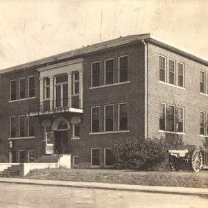 Three story brick building with cannon at the side