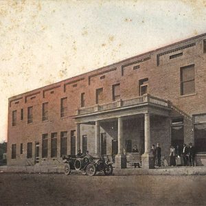 Car parked in front of two story red brick building