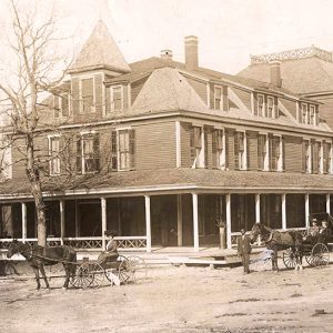 Horses and buggies in front of large