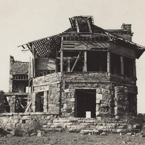 Remains of multistory stone building with gaping holes and decrepit roof