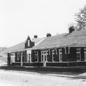 Single story brick building beside railroad tracks