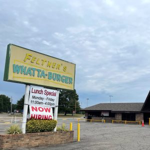 Business sign "Feltners Whatta-Burger" in front of single story building