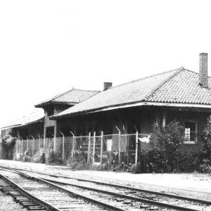 Single story brick building beside railroad tracks