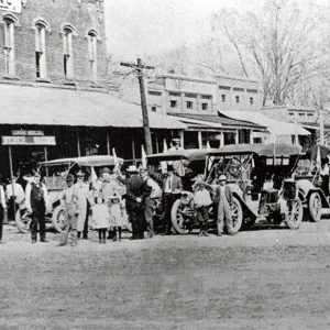 Multitude of cars and people in street before buildings