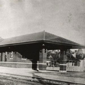 Single story brick building beside railroad tracks