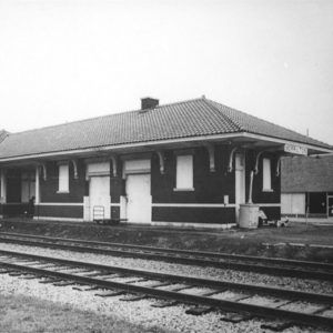 Single story brick building beside railroad tracks