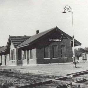 Single story brick building beside railroad tracks