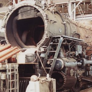 Partially disassembled locomotive in large interior space