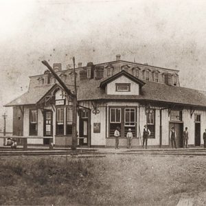 Single story wooden building beside railroad tracks