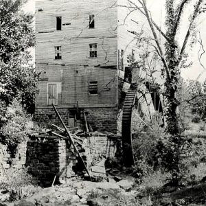 Multistory wooden building with water wheel on the side