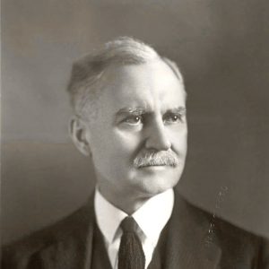 Mustachioed white man in suit