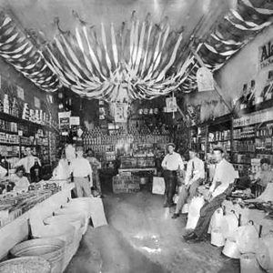 White people standing and leaning in store amid shelves and piles of goods