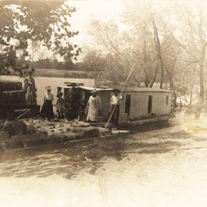 People and goods on pole barge on river