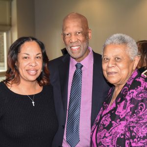 African-American man standing between two African American women