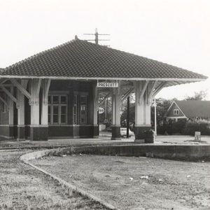 Single story wooden building next to railroad tracks