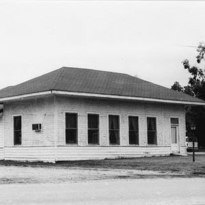 Single story wooden building with row of windows