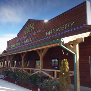 Multistory wooden building with long porch and "Bubba Brew's" in lights