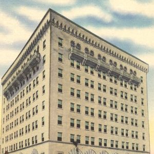 eight-story white brick building with arched detail above first-floor windows