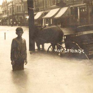 White child standing in street covered in water